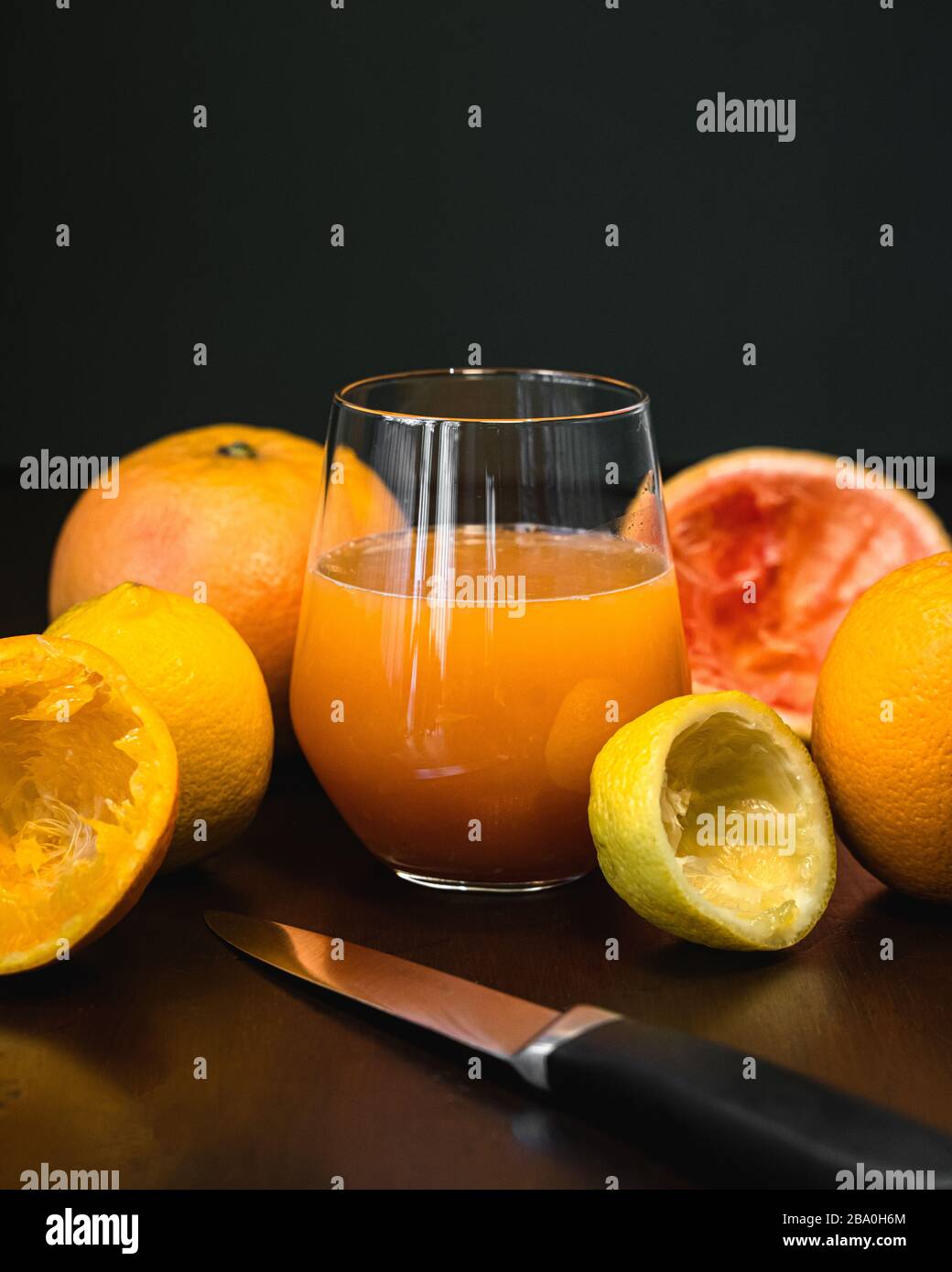 Un bicchiere di succo di frutta appena spremuto e arancia fresca al limone e pompelmo Foto Stock