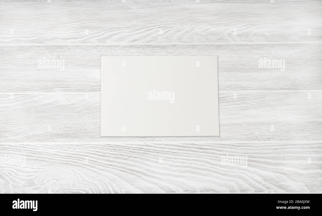 Carta a fogli bianchi su tavolo di legno bianco. Sfondo in legno bianco. Foto Stock