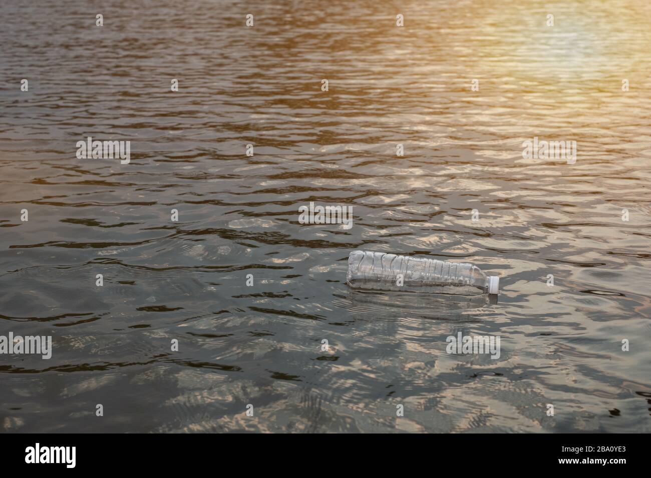 Bottiglia di plastica per rifiuti usata che galleggia sull'acqua in un canale, approccio ecologico concetto di inquinamento e ambiente Foto Stock