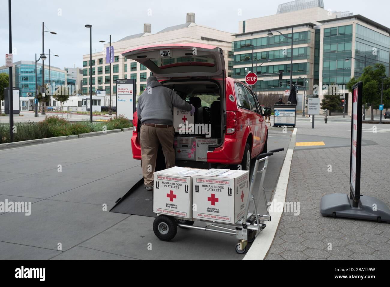 Una persona carica le scatole etichettate Red Cross Human Blood Platelets in un veicolo all'ingresso del centro medico dell'Università della California di San Francisco (UCSF) a Mission Bay durante uno scoppio del coronavirus COVID-19 a San Francisco, California, 23 marzo 2020. () Foto Stock