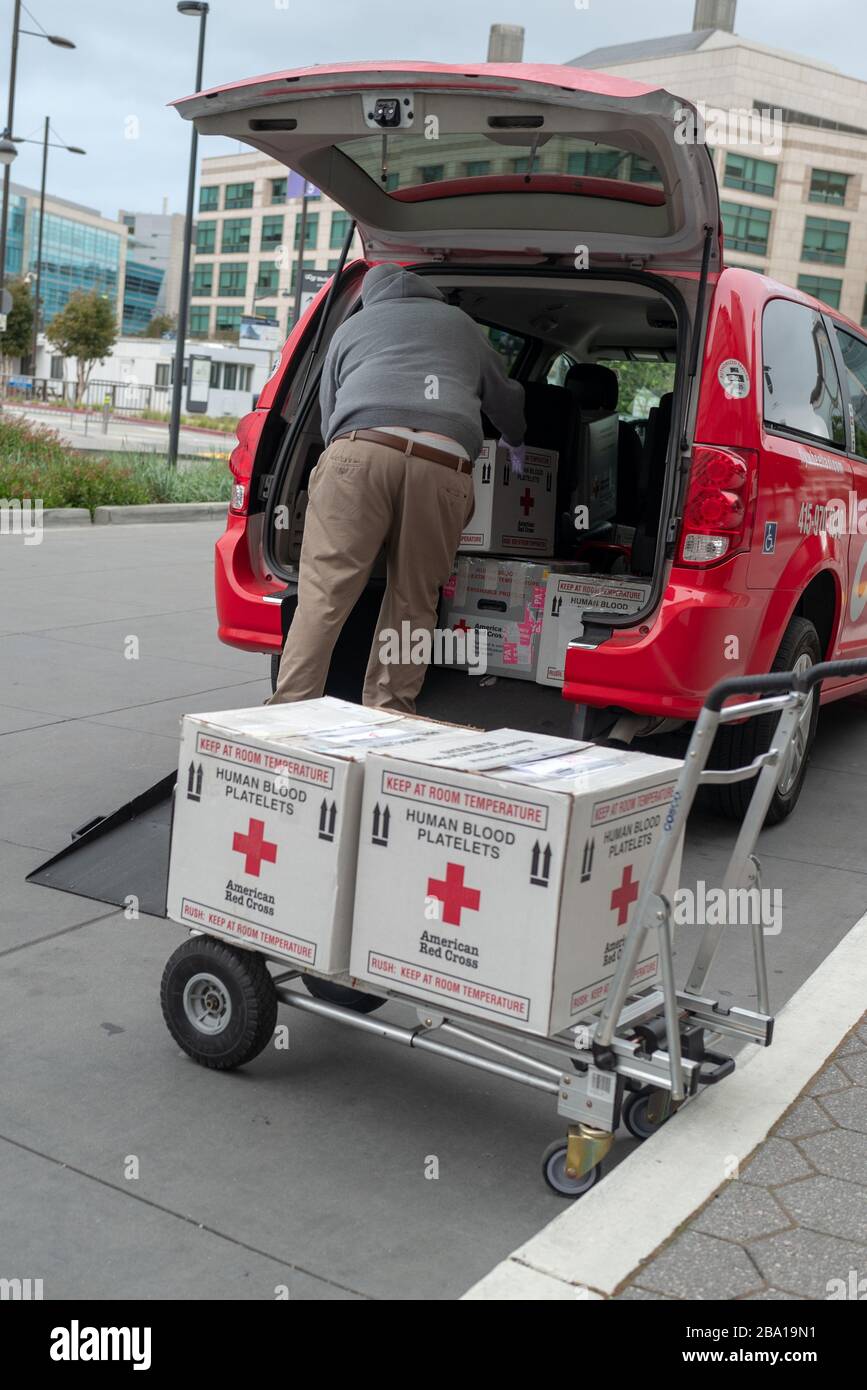 Una persona carica le scatole etichettate Red Cross Human Blood Platelets in un veicolo all'ingresso del centro medico dell'Università della California di San Francisco (UCSF) a Mission Bay durante uno scoppio del coronavirus COVID-19 a San Francisco, California, 23 marzo 2020. () Foto Stock