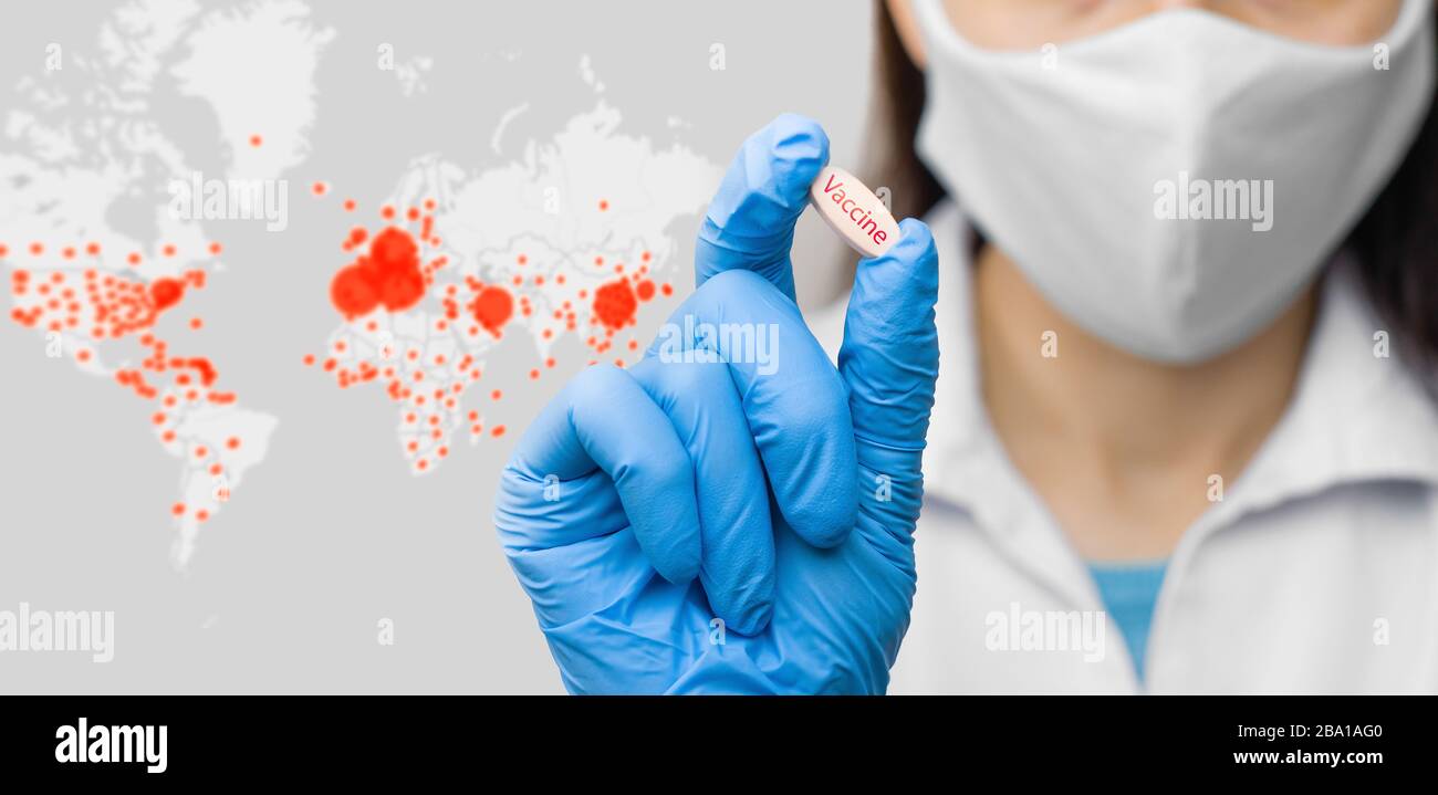 Sulla mappa globale del coronavirus sfondo è una pillola in una mano in guanti blu. La femmina è in possesso di un vaccino contro il coronavirus, 2019-nCoV, SARS-nCov Foto Stock