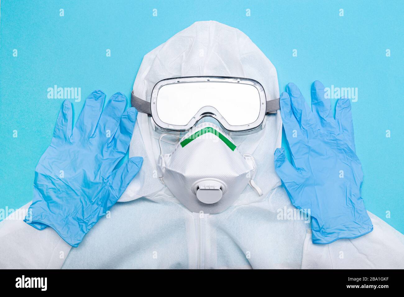 Tuta protettiva per combattere l'epidemia di virus Coronavirus COVID-19. Indumenti di sicurezza isolati su sfondo blu Foto Stock