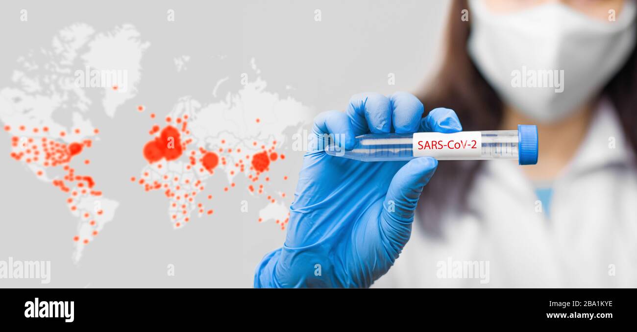 Sulla mappa online del coronavirus sfondo è una provetta con vaccino contro il coronavirus, 2019-nCoV, SARS-Cov-2, COVID-19 in mano scienziato indossare Foto Stock