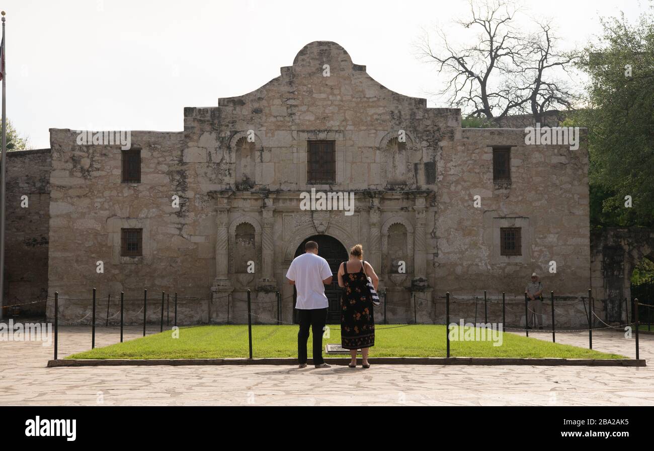 Solo due turisti e un Texas Ranger stand di fronte al famoso Alamo , 25 marzo 2020 a SAN ANTONIO, Texas., il sito patrimonio mondiale dell'UNESCO è chiuso a causa della diffusione del Coronavirus Covid-19. San Antonio ha emanato una regola per il soggiorno a casa dei suoi cittadini. Foto Stock