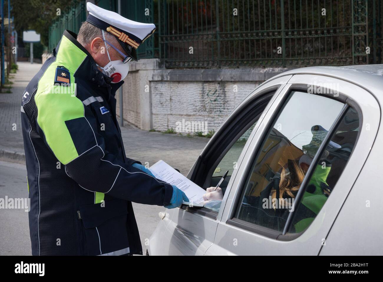 Campobasso,Regione Molise,Italia:un poliziotto urbano controlla l'autodichiarazione di una persona per circolare durante l'emergenza del coronavirus a Campobasso. Foto Stock