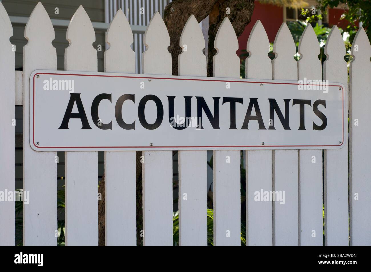 Vista di un cartello di Accountants appeso di fronte ad un recinto di legno bianco a Bangalow, Australia Foto Stock