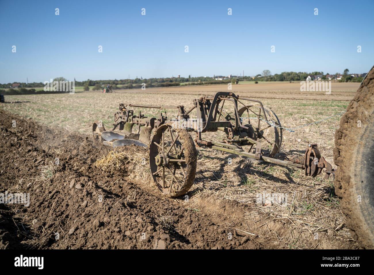 Vecchio e antico fordson tractorr lavorando con un aratro nei campi, mostrando come l'agricoltura è stata fatta molti anni fa. Foto Stock