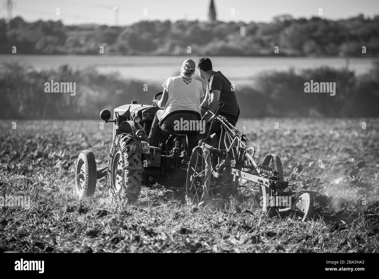 Vecchia e antica Lanz Bulldog tractorr lavorando con un aratro nei campi, mostrando come l'agricoltura è stato fatto molti anni fa. Foto Stock