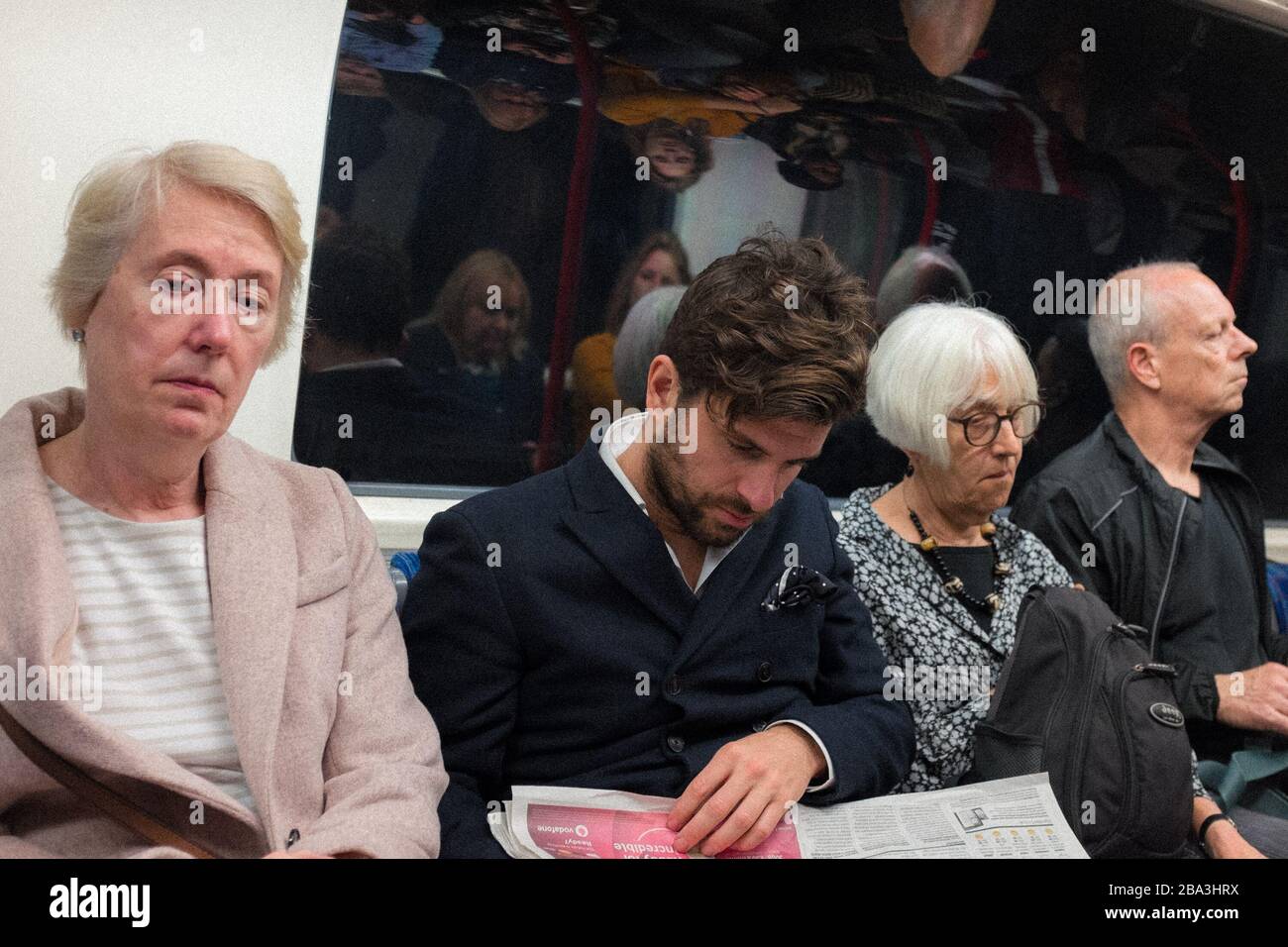 Persone sedute sulla metropolitana di Londra, Londra, Regno Unito Foto Stock