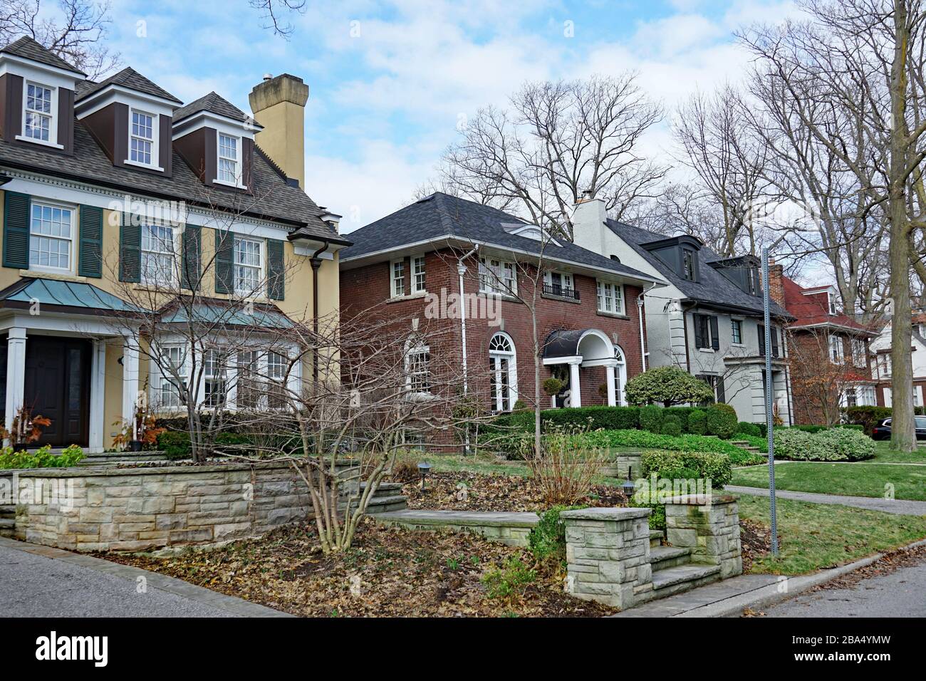 Strada residenziale con grandi case indipendenti con cortili anteriori con alberi maturi Foto Stock