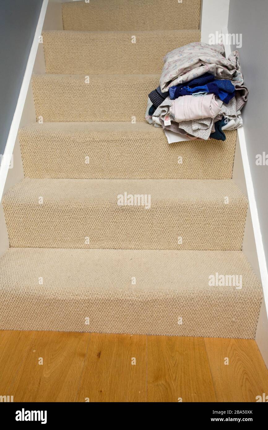 Pile lavate di vestiti lasciati sulle scale Foto Stock
