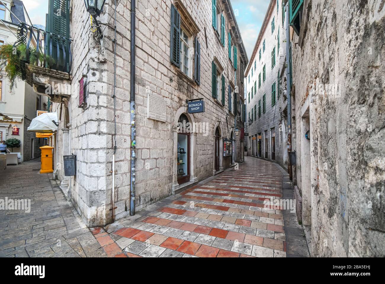 Piccoli negozi e caffè la linea di una pittoresca strada medievale nel centro storico della città costiera di Kotor, Montenegro, sulla costa Adriatica. Foto Stock