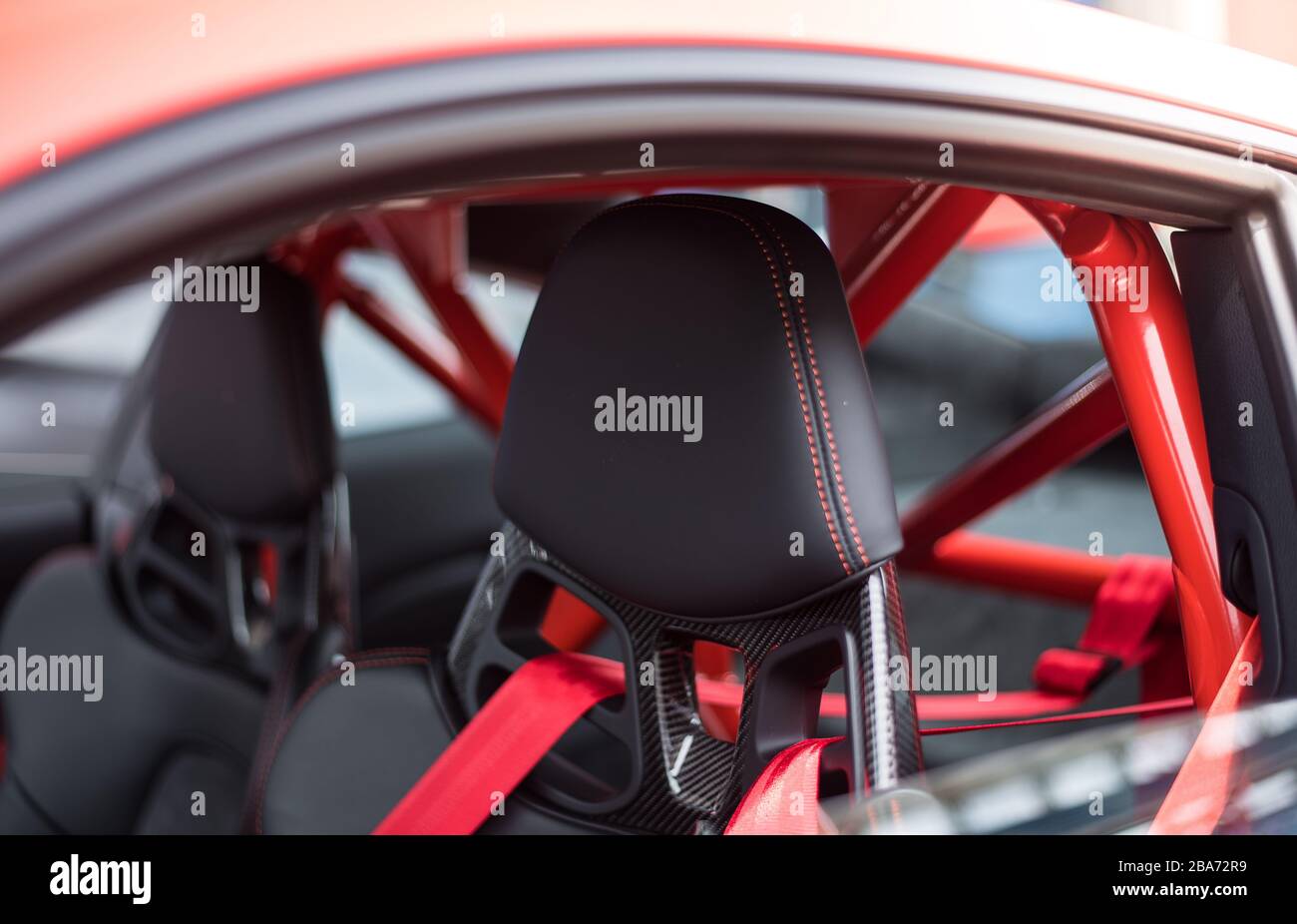 Sedili neri e cinture di sicurezza rosse di un'auto rossa Foto stock - Alamy
