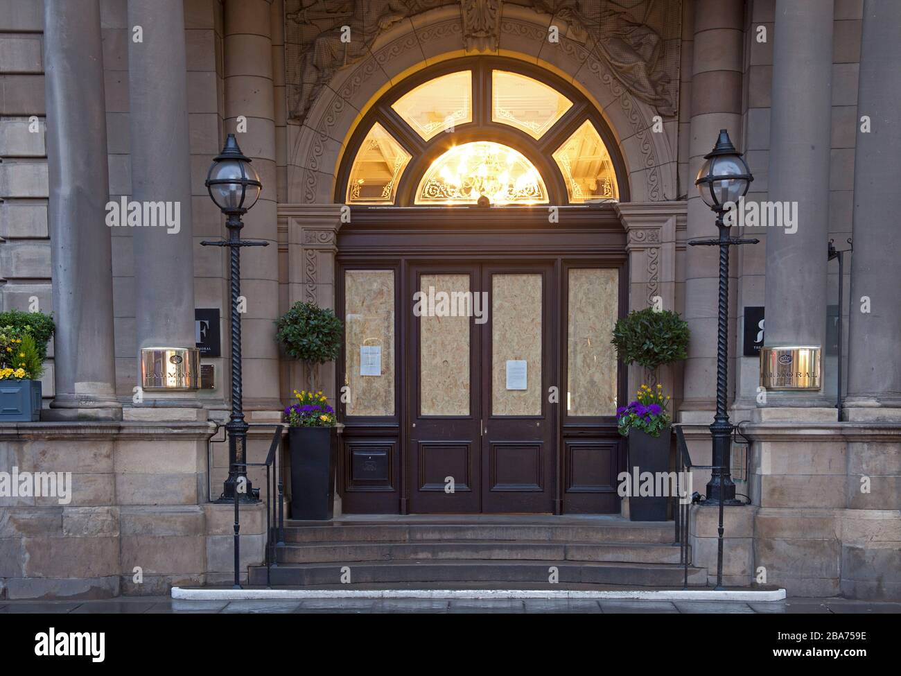 Princes Street, Edimburgo, Scozia, Regno Unito. 26th Mar 2020. Le luci sono accese ma nessuno è a casa all'ingresso dell'Hotel Balmoral. In questo terzo giorno di Covid-19 Lockdown nel Regno Unito, Princes Street si sveglia per scoprire che il Balmoral Hotel è chiuso con le finestre a bordo e i proprietari hanno sospeso le attività per un periodo di tempo limitato. Ora di proprietà di Rocco Forte Hotels. Nel 1902 - l'hotel è stato inaugurato il 15 ottobre come North British Station Hotel, l'unico edificio residenziale mai costruito sul lato sud di Princes Street. Foto Stock