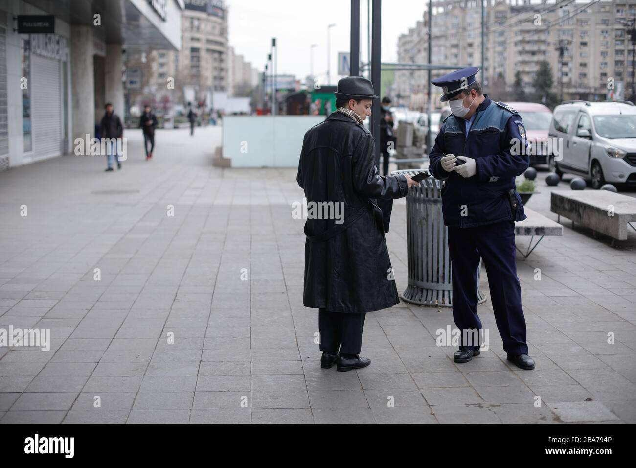 Bucarest, Romania - 25 marzo 2020: La polizia chiede alle persone di mostrare documenti di identità per applicare un giorno intero di blocco per limitare la diffusione del coronavirus. Foto Stock