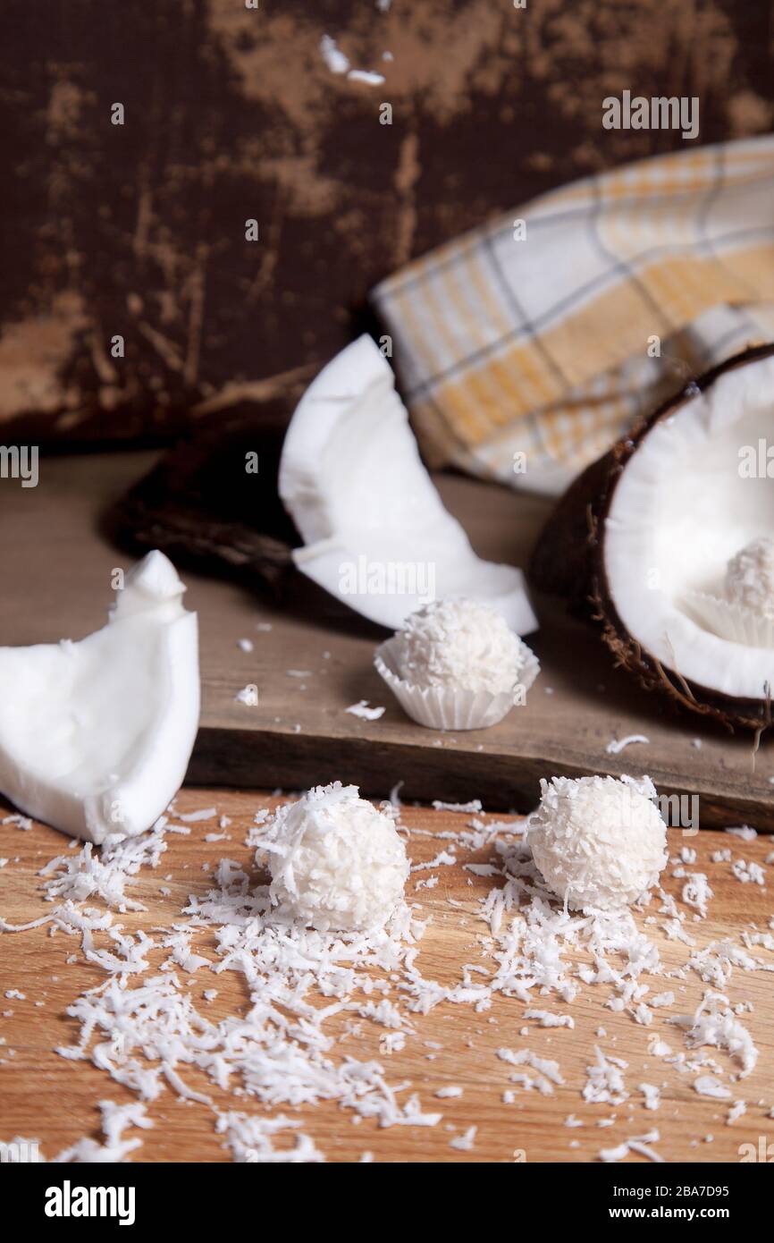 Primo piano di tartufi di cocco cioccolato dolce e cocco con polpa bianca, chip di cocco. Cioccolato bianco cocco dolci e guscio di cocco, cocco flak Foto Stock