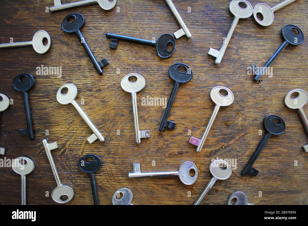 Molte chiavi su sfondo di legno marrone . Foto Stock