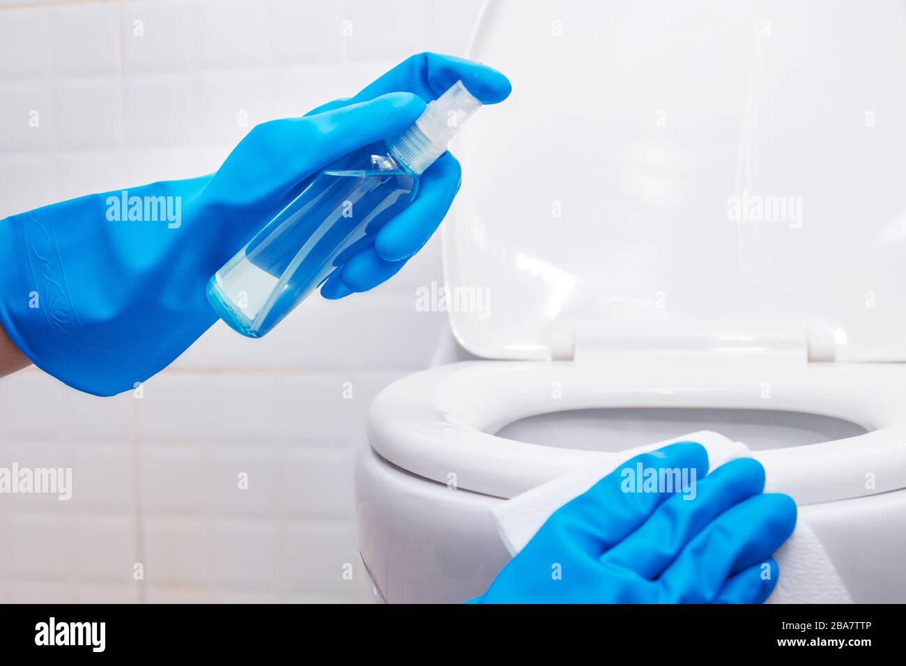 disinfettare, sanificare, igiene. persone che utilizzano spray imbevuto di alcol sul coperchio del sedile del gabinetto e l'area a contatto frequente per la pulizia e la disinfezione, prevenzione Foto Stock