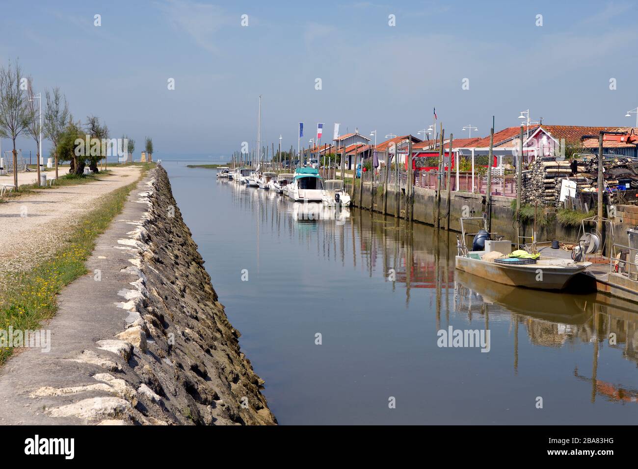 Barche e chiatta nel porto di Audenge, comune è un situato sulla riva nord-orientale della baia di Arcachon, in Francia Foto Stock