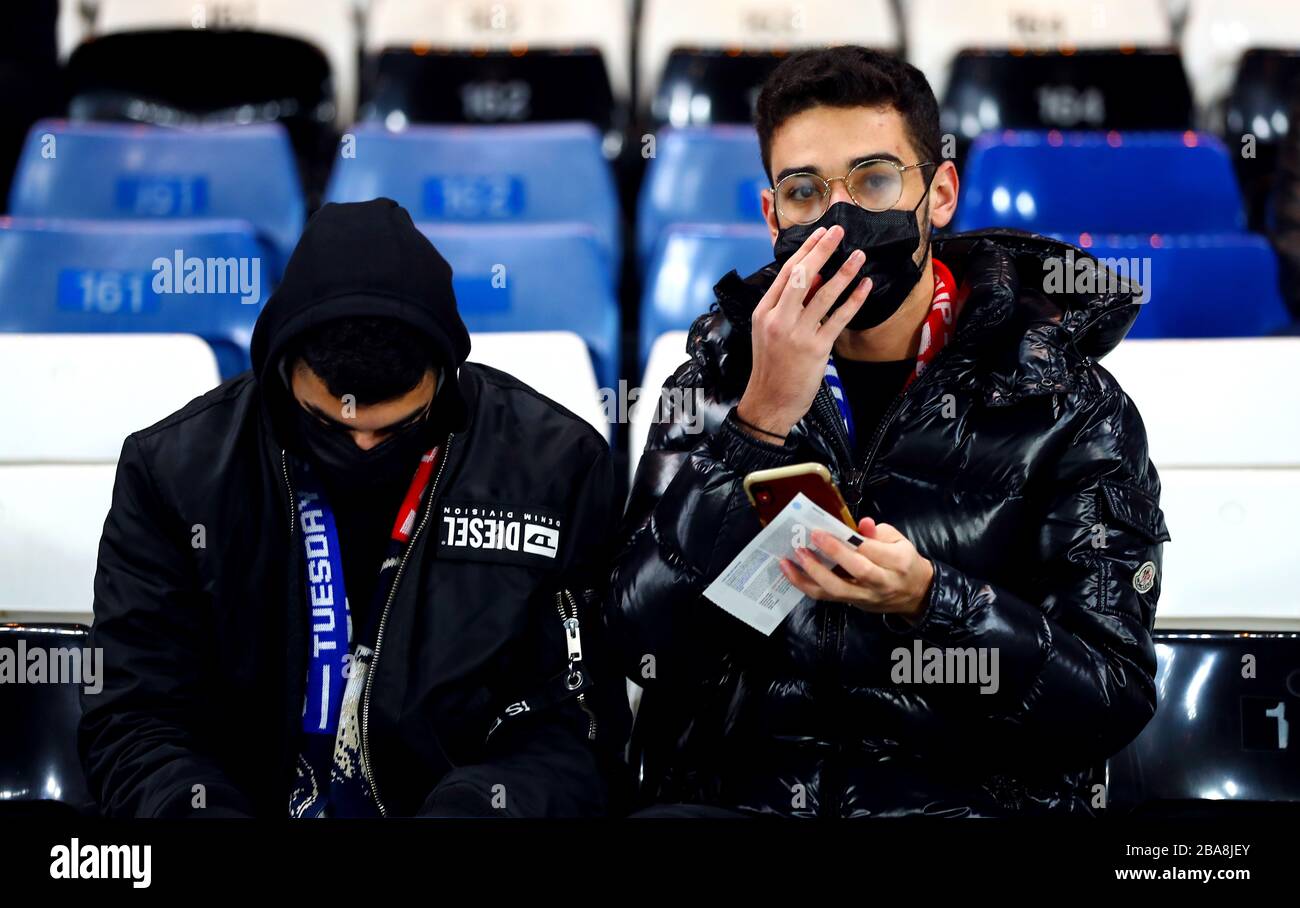 Due fan negli stand indossando maschere facciali prima del gioco Foto Stock