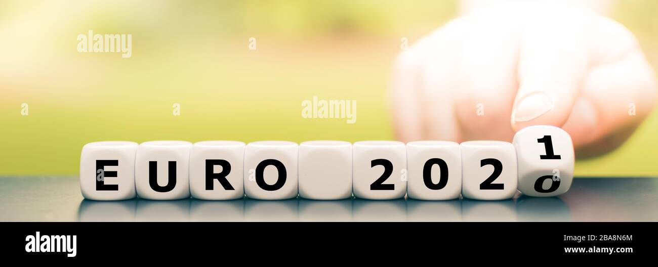 La mano gira i dadi e cambia l'espressione "Euro 2020" in "Euro 2021". Foto Stock