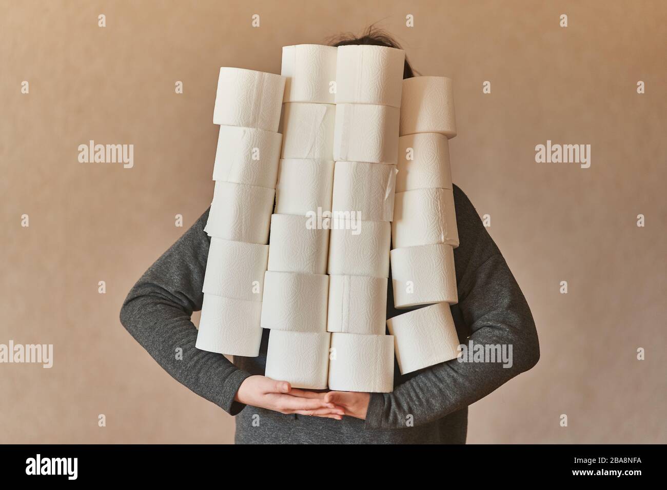 Una ragazza tiene molti rotoli di carta igienica. Quarantena durante il coronavirus. Foto Stock
