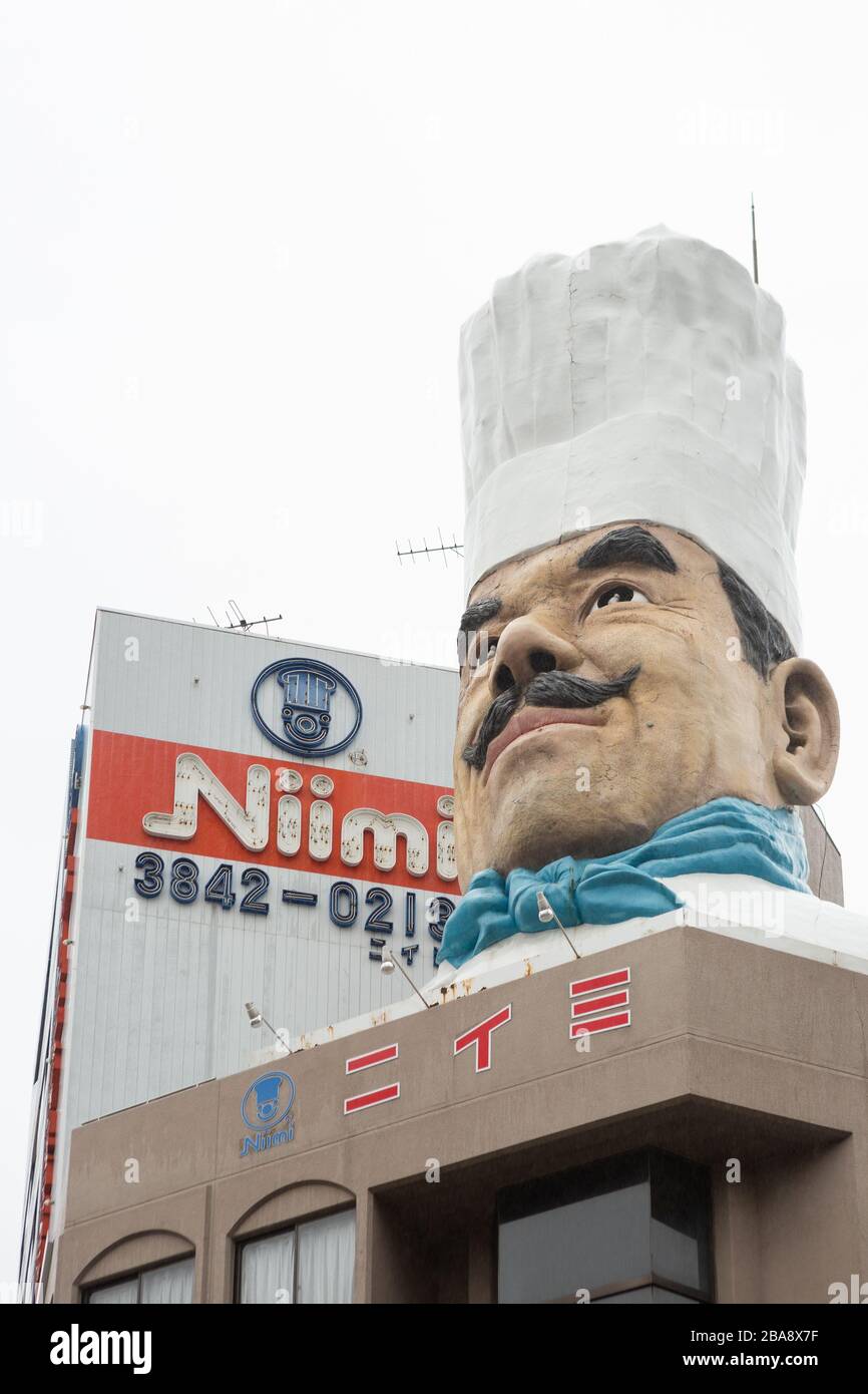 Statua gigante della testa di uno chef in cima a un edificio, Kappabashi-dori, Tokyo, Giappone Foto Stock