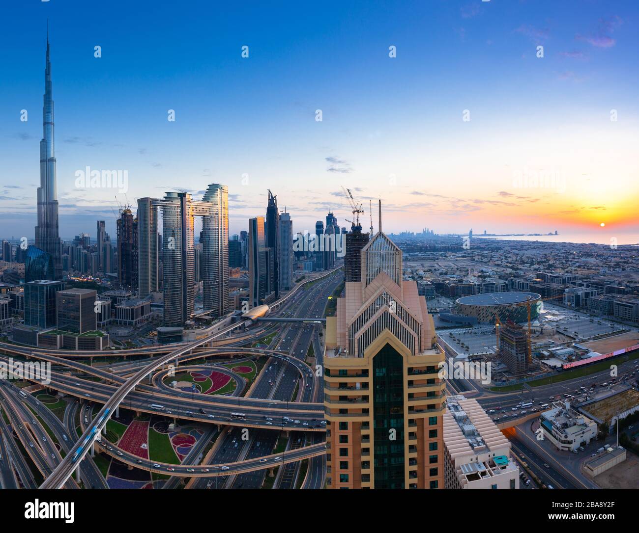 La vista dello skyline di Dubai con Burj Khalifa, Sheikh Zayed Road e il tramonto sul golfo, Emirati Arabi Uniti. Foto Stock