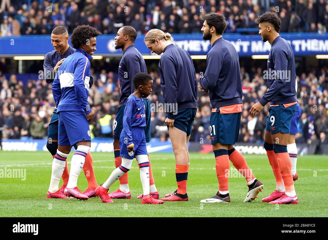 I giocatori di Chelsea ed Everton si oltrepassano l'uno dall'altro cercando di evitare i frullati prima del calcio d'inizio Foto Stock