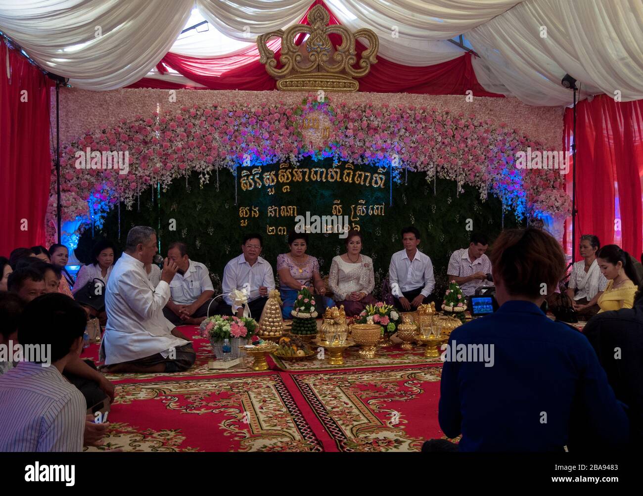 Kampot, Cambogia, Asia: Celebrazione di un matrimonio in presenza di parenti e amici dei coniugi, mentre un operatore video spara un video Foto Stock