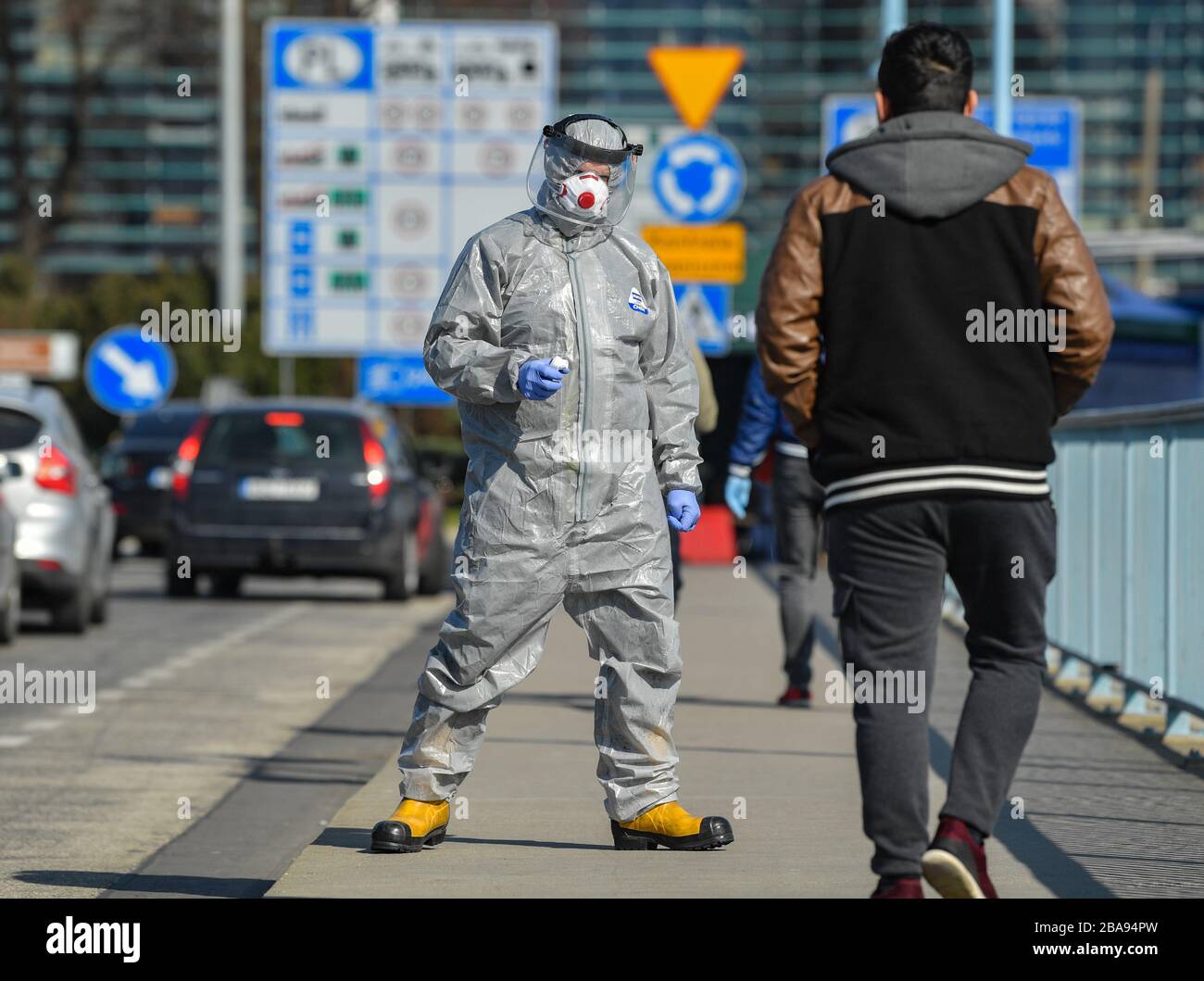 Slubice, Polonia. 26 marzo 2020. Un uomo in tuta protettiva si erge con un  termometro sul ponte della città, il confine tedesco-polacco che attraversa  Francoforte (Oder) verso la città polacca di Slubice,