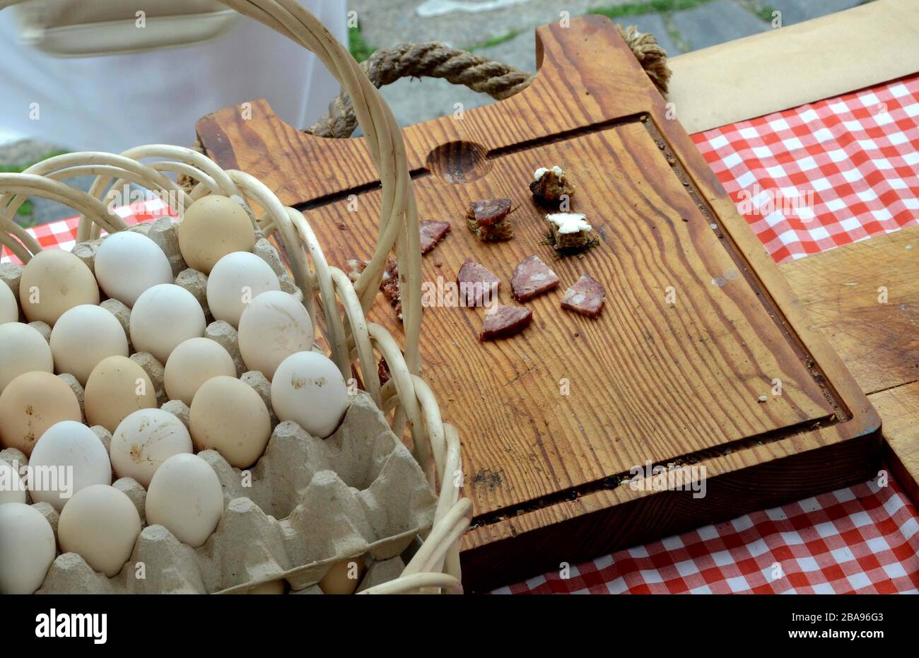 Un vassoio con uova di campagna e una tavola con un paese, salsiccia casalinga, tagliato a pezzi per la degustazione e la prova. Foto Stock