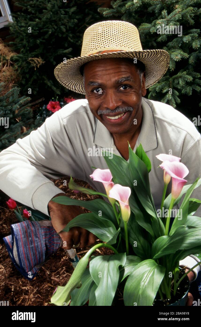 African American uomo di mezza età in cappello in giardino, ritratto Foto Stock