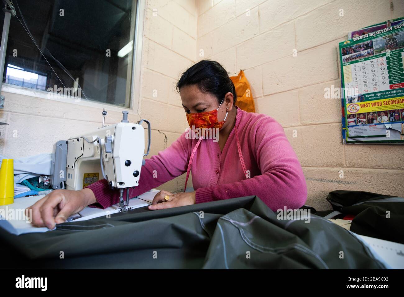 Lalitpur, Nepal. 26 marzo 2020. Un membro dello staff dell'ospedale di Patan indossa una maschera protettiva che cucisce i dispositivi di protezione individuale (DPI) durante il blocco in mezzo alle paure di Coronavirus a Lalitpur. Credit: SOPA Images Limited/Alamy Live News Foto Stock
