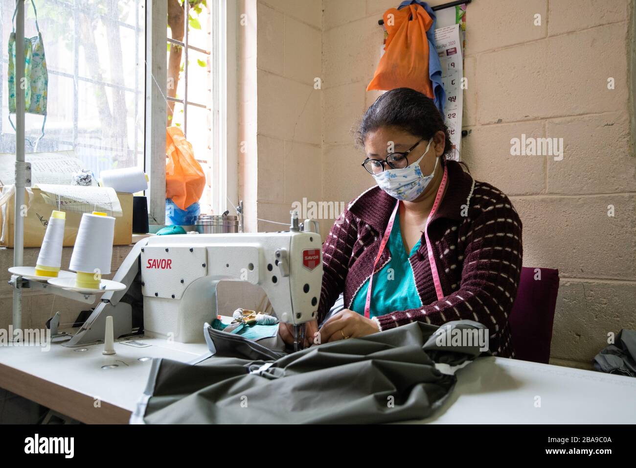 Lalitpur, Nepal. 26 marzo 2020. Un membro dello staff dell'ospedale di Patan indossa una maschera protettiva che cucisce i dispositivi di protezione individuale (DPI) durante il blocco in mezzo alle paure di Coronavirus a Lalitpur. Credit: SOPA Images Limited/Alamy Live News Foto Stock