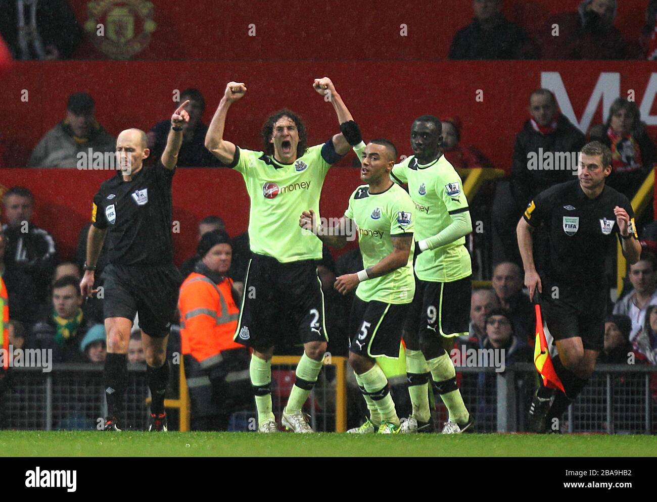 (Da sinistra a destra) Fabricio Coloccini, Danny Simpson e Papiss Cisse del Newcastle United celebrano come arbitro Mike Dean (a sinistra) premia il proprio obiettivo Foto Stock