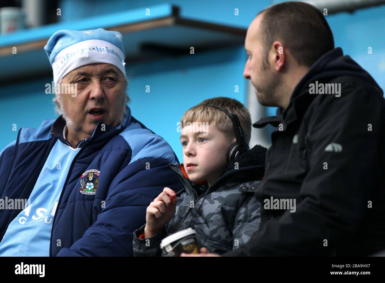Un fan di Coventry City che indossa un cappello blu cielo di santa negli stand Foto Stock