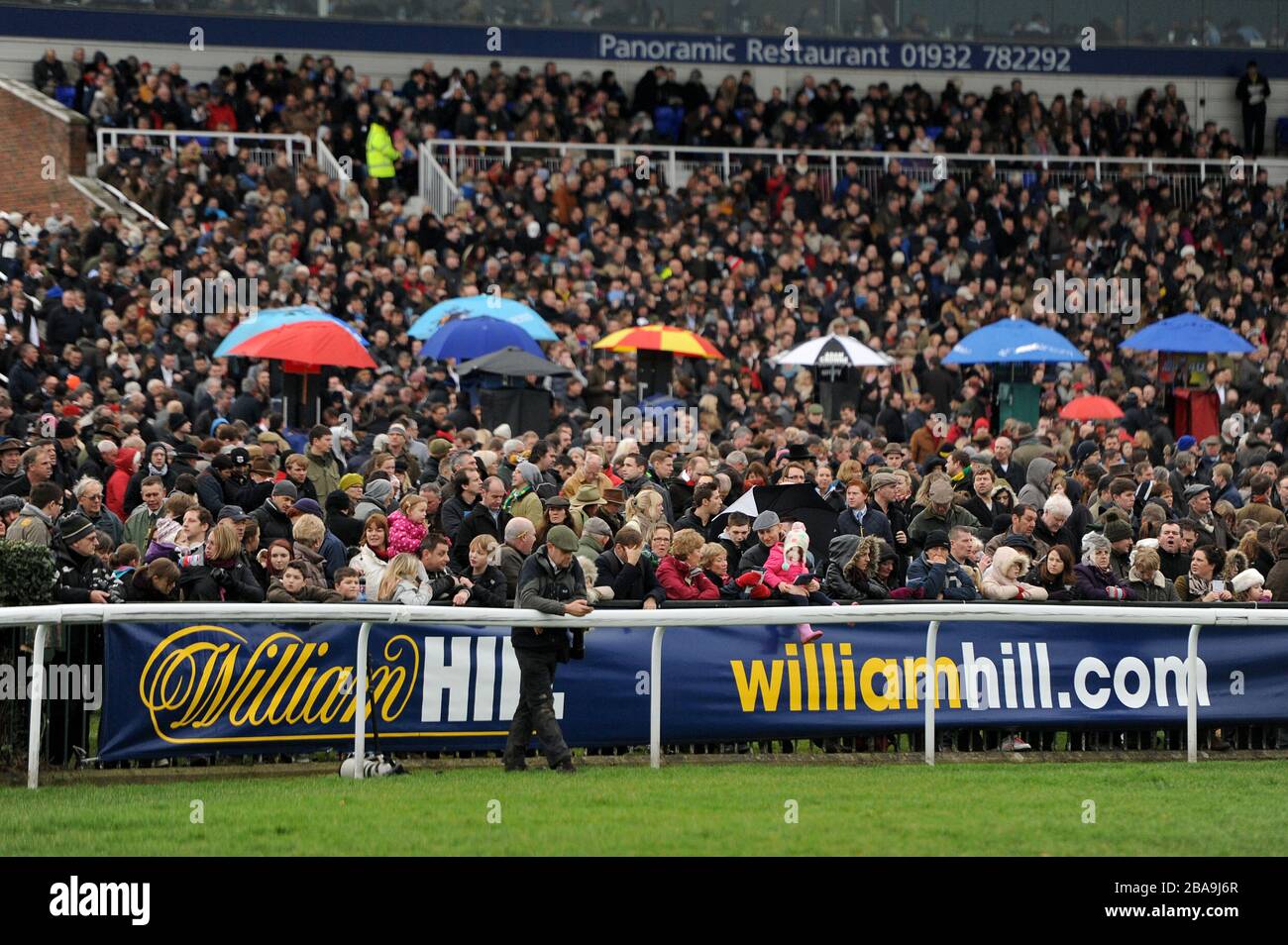 All'ippodromo di Kempton Park, una folla piena di registi è vista oltre le indicazioni di William Hill Foto Stock