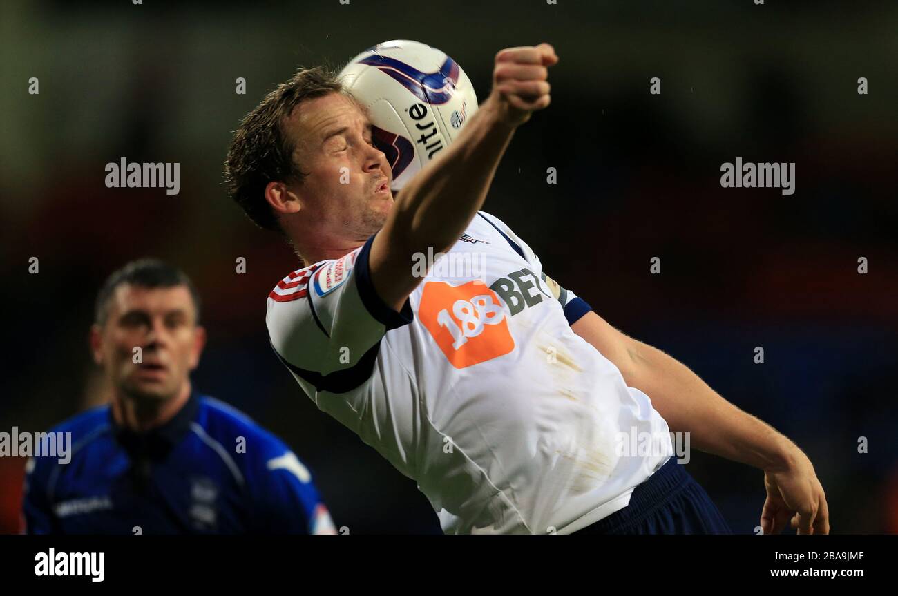 Kevin Davies di Bolton Wanderers ottiene una palla che smash nel lato del suo viso Foto Stock