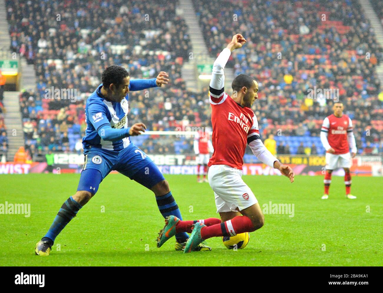 Il Theo Walcott dell'Arsenal (a destra) è colto nella zona di rigore da Jean Beausejour di Wigan Athletic Foto Stock