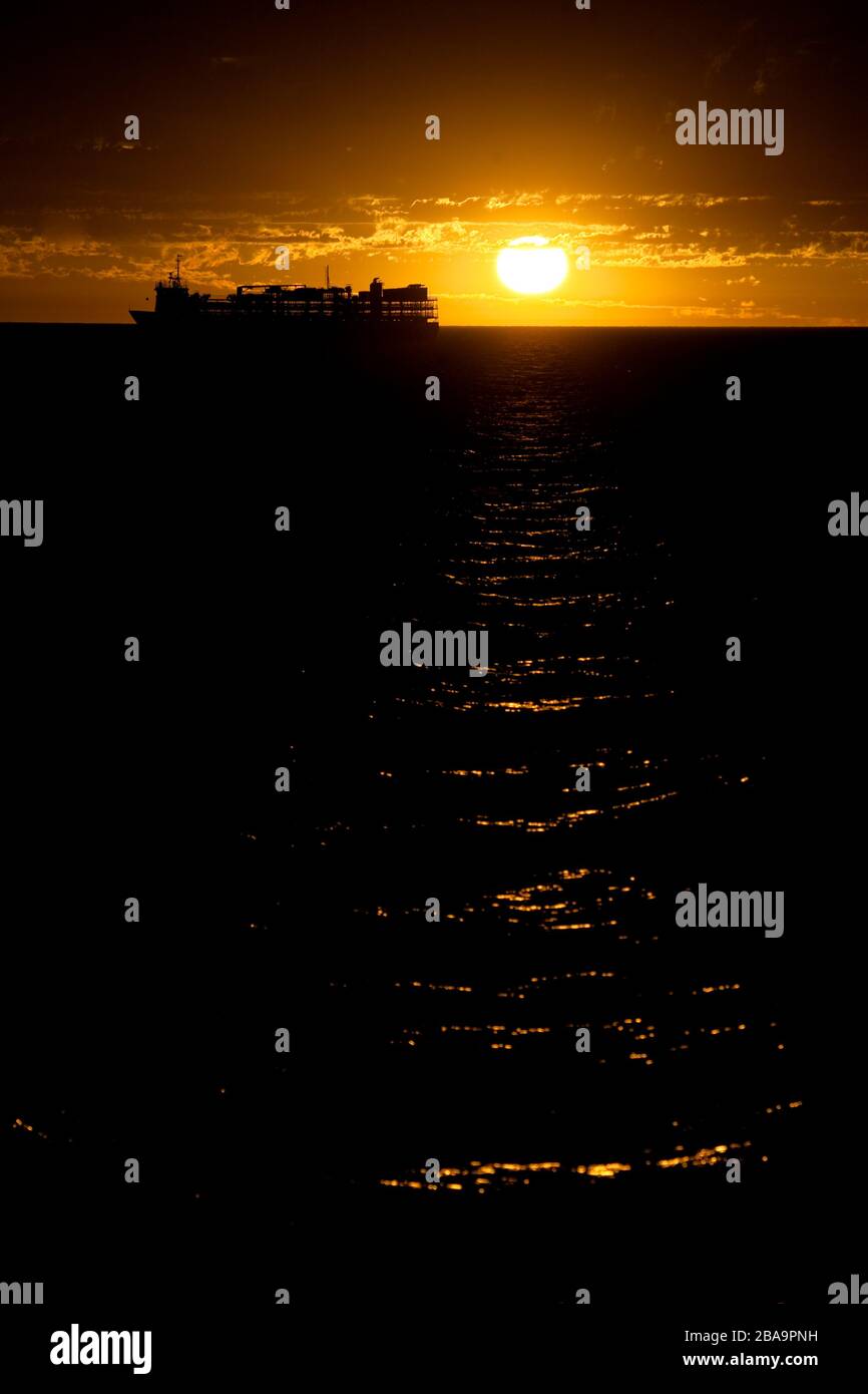 Una crociera ancorò i terreni offshore in un epico tramonto rosso sangue. Australia occidentale Foto Stock