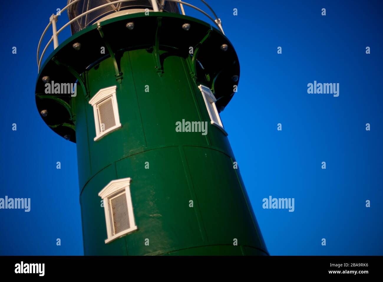 Il verde dipinto South Mole Lighthouse, nella baia di Fremantle, Australia Occidentale al tramonto Foto Stock