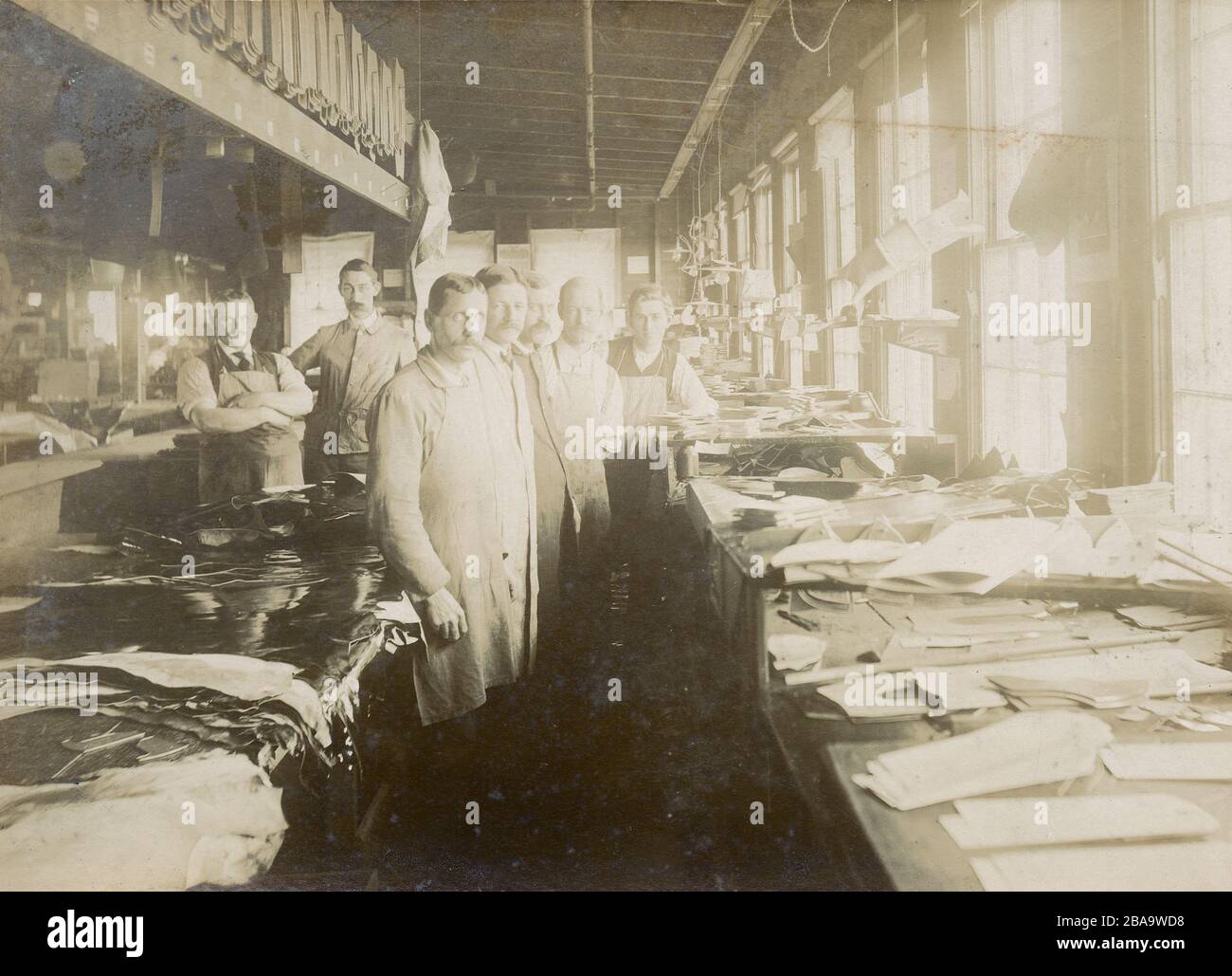 Fotografia antica del 1910 circa, gruppo di uomini in un laboratorio di lavorazione del cuoio con diversi disegni visibili. Posizione esatta sconosciuta; vicino a Boston, Massachusetts. FONTE: INCISIONE ORIGINALE Foto Stock