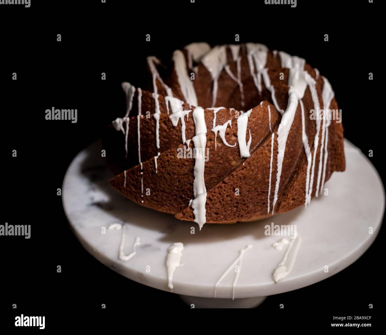 Torta di zucca Swirl Bundt su torta di marmo Stand contro sfondo nero Foto Stock