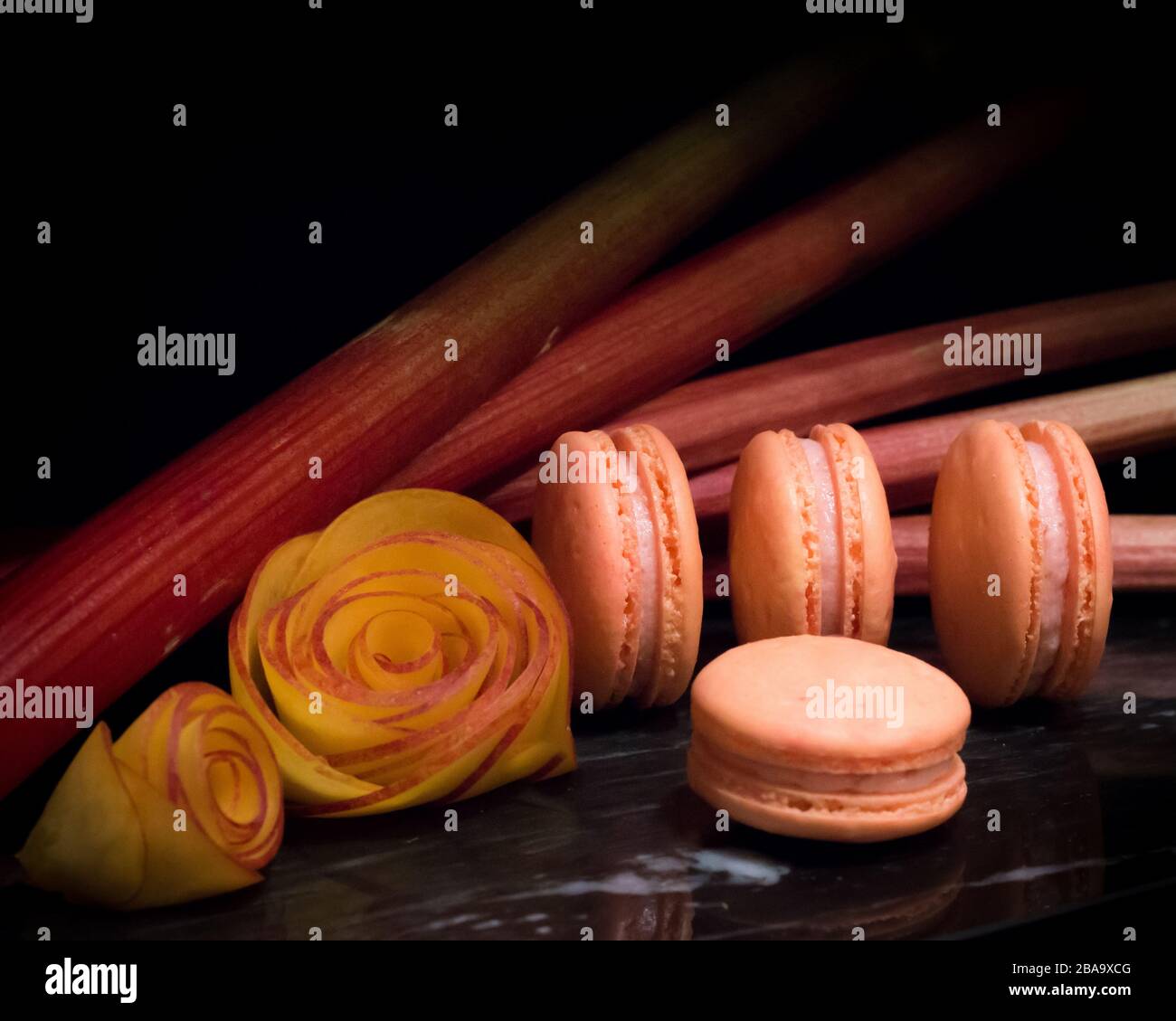 Macarons di Rhubarb di pesca contro uno sfondo nero Foto Stock