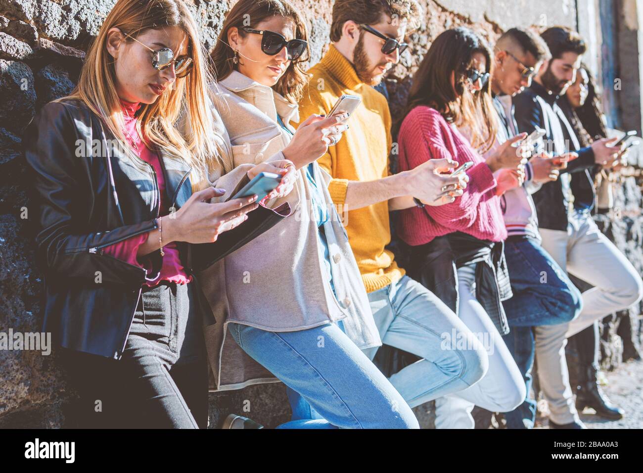 Generazione millenaria di persone che utilizzano smartphone. Giovani dipendenti dal concetto di dipendenza delle applicazioni di social network. Amici che usano i telefoni cellulari ag Foto Stock