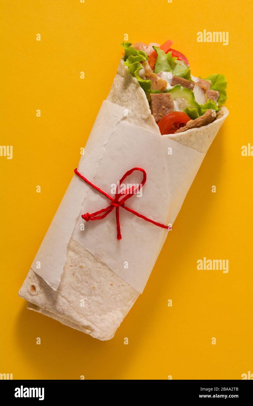 Doner kebab o shawarma sandwich isolato su sfondo giallo. Vista dall'alto. Foto Stock