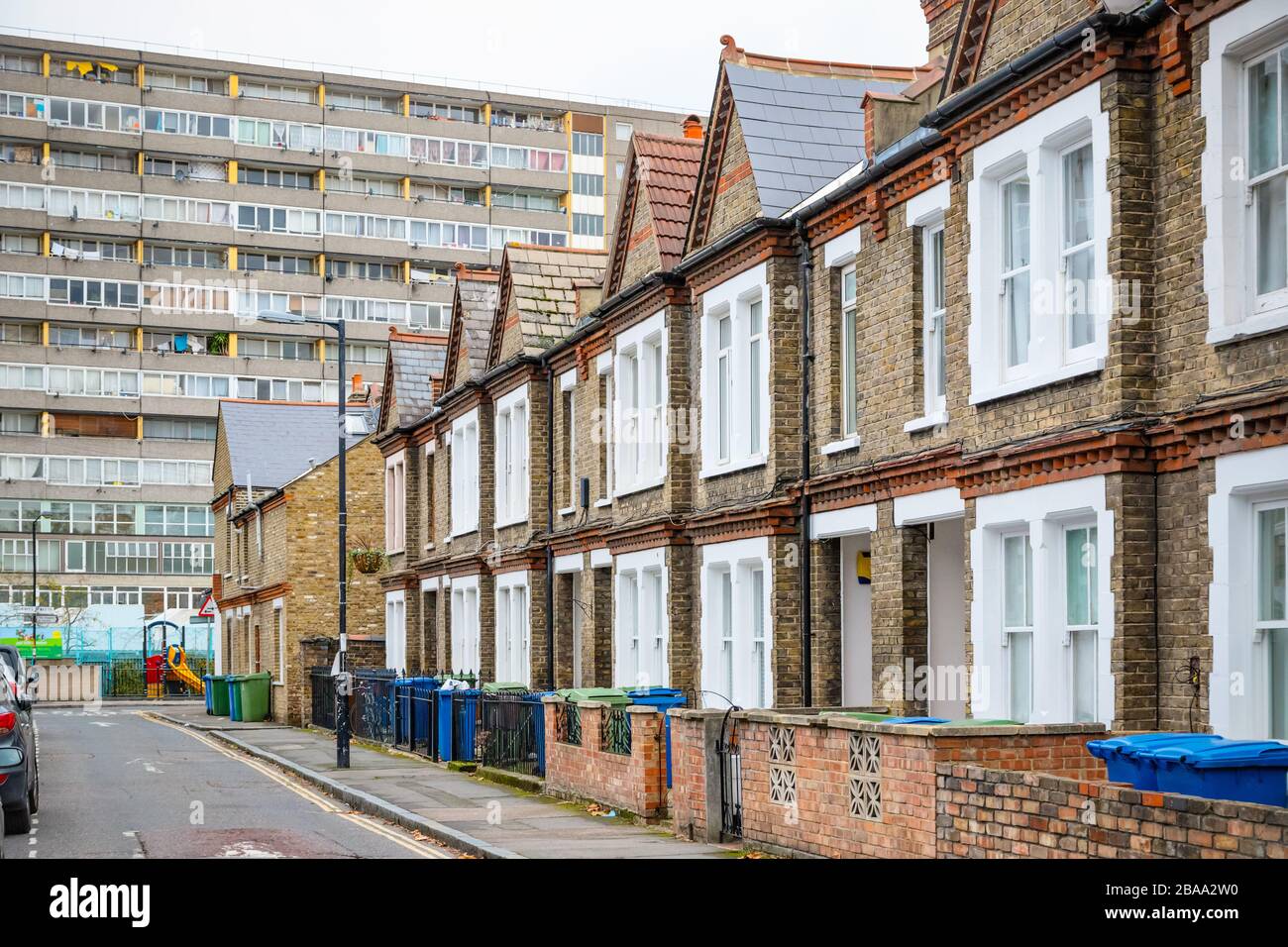 Tradizionali case a schiera inglesi con enorme blocco consiglio Aylesbury Estate in background nel sud-est di Londra Foto Stock