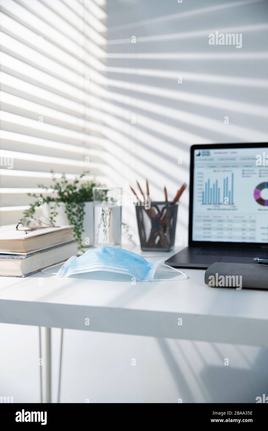 Forniture per ufficio e maschere monouso sulla scrivania Foto Stock